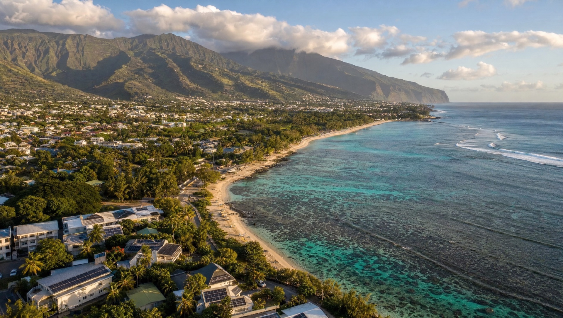 Vue aérienne du lagon de la côte ouest de La Réunion (974) avec des toitures équipées de panneaux solaires photovoltaïques
